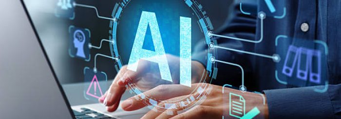 Businessman typing on laptop computer keyboard at desk in office.
